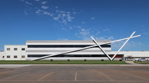 Exterior view of Alliance Steel building with striking angular architectural design under a clear blue sky.