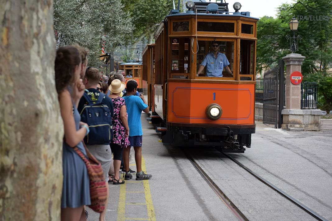 Menschen warten in Sóller auf die historische Straßenbahn, die gerade einfährt
