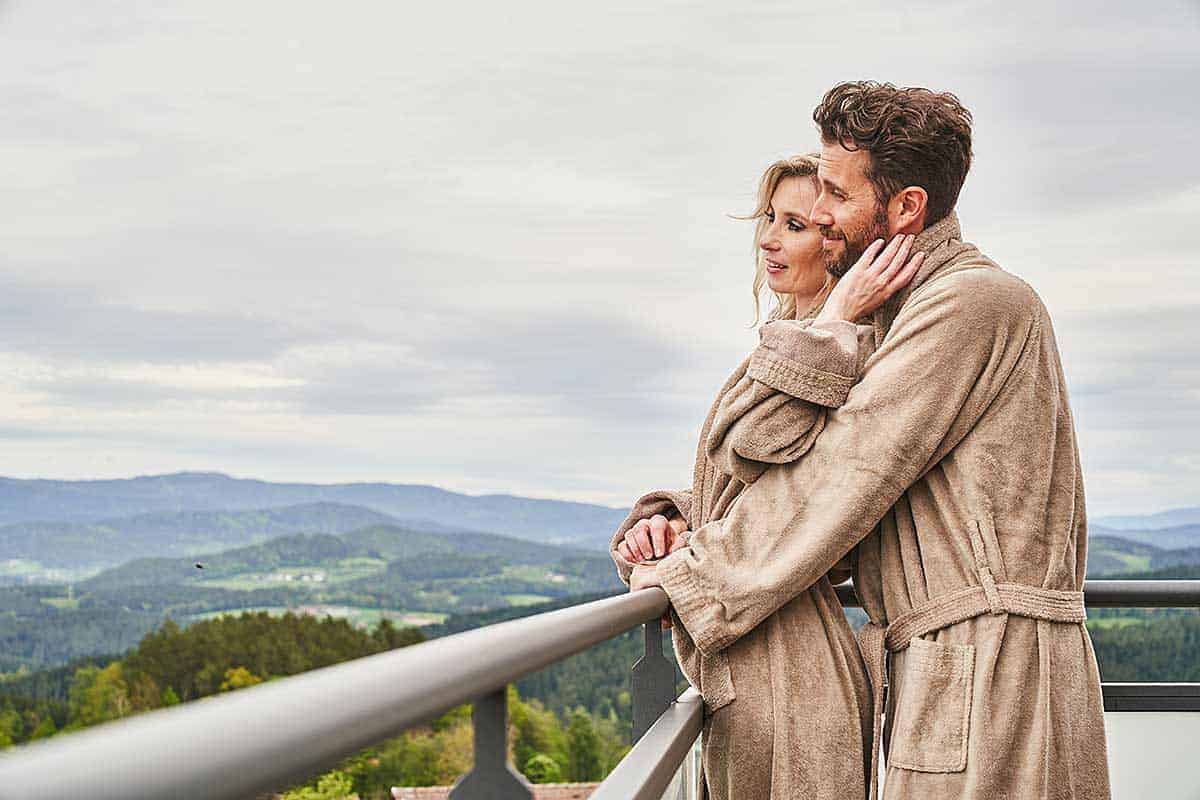 Verliebtes Paar genießt den Traumblick von der Terrasse einer Suite unseres Wellnesshotels