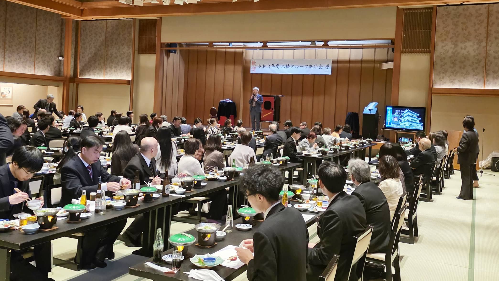 【2026年版】出張マジシャンの料金はいくら?シーン別・規模別の費用相場をプロが本音で解説 7 和倉温泉のと楽の満席の大宴会場でマジックショーに見入る八幡のすしべんの社員の皆さんと出張マジシャン・コンプレッサー