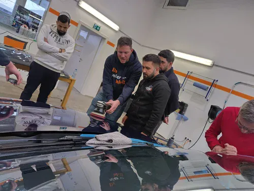 TopCar Autoaufbereitung Kurs Österreich Baden bei Wien Gruppe von Autoaufbereitern üben das Polieren