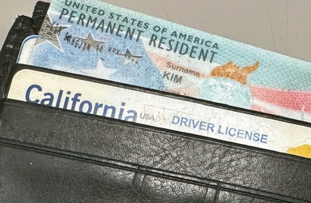 Korean American carrying a green card and a driver’s license together in a wallet, reflecting increased USCIS scrutiny and documentation concerns
