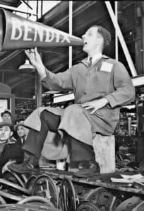 Bendix Sit-down Strike ph 1530 Historical museum exhibit of a man with a megaphone speaking to a crowd, reflecting American history and cultural preservation.
