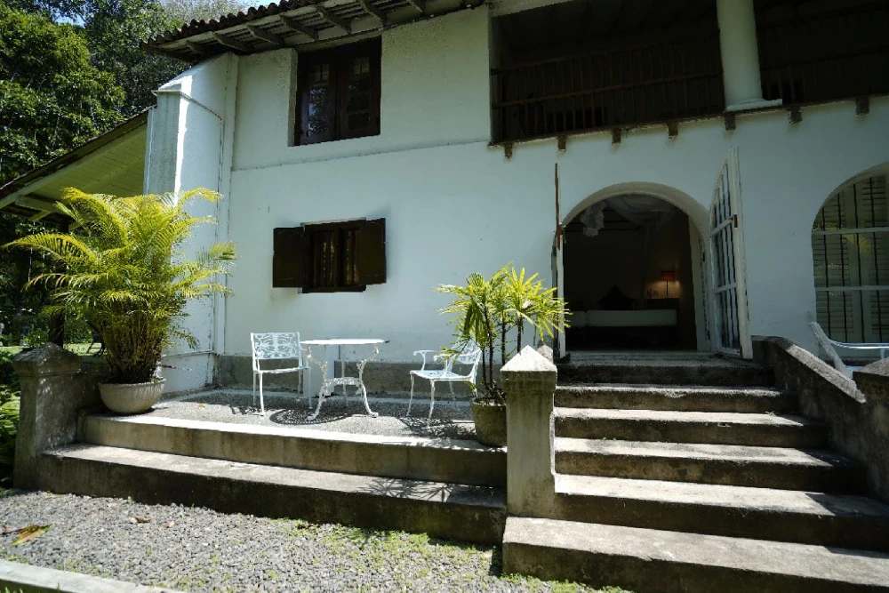 Outside view of Adigar's Manor, showcasing a patio with a table for gatherings.