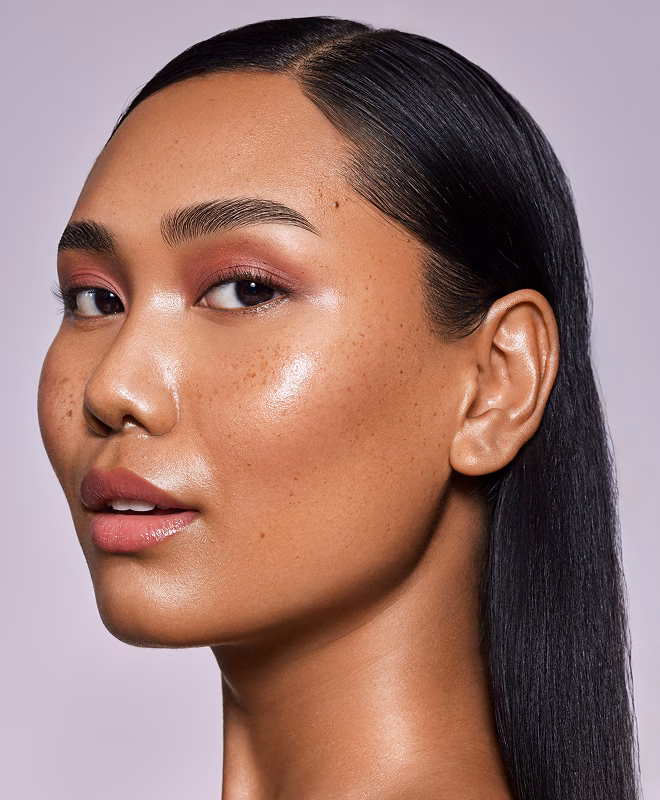Person mit rosa Make-up und glattem, schwarzem Haar, das hinter dem Ohr nach hinten gelegt ist