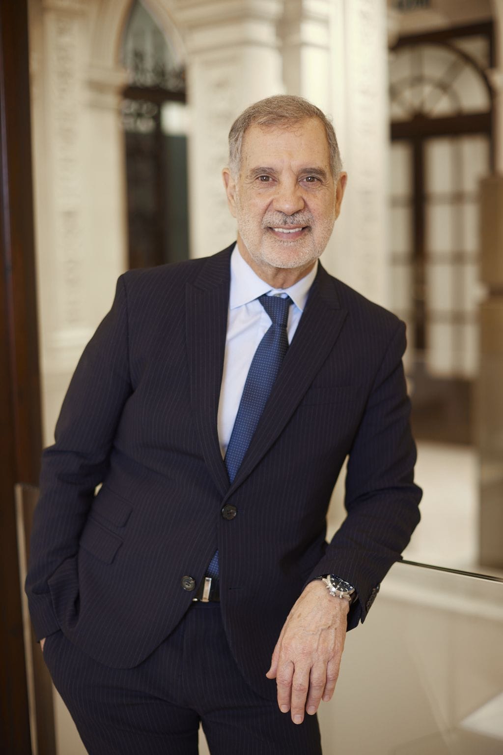 Hombre mayor en traje, elegante y seguro en oficina moderna, mostrando profesionalismo y éxito.