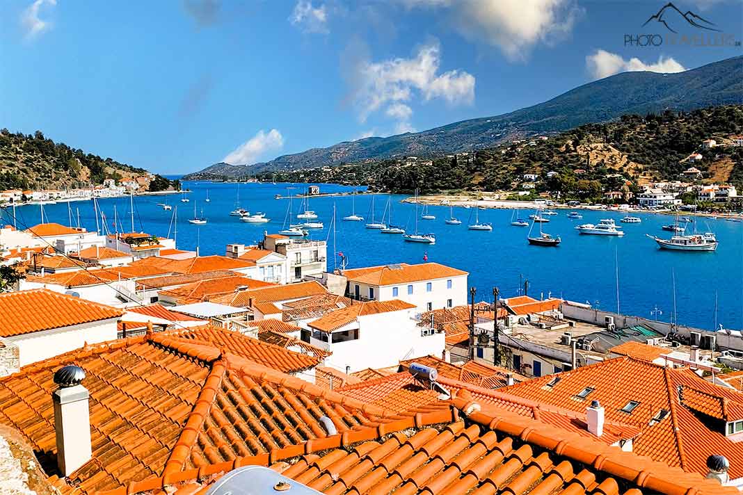 Blick über die orangen Ziegeldächer von Poros auf die Meerenge und auf Galatas