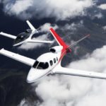 A close up of a propeller plane that is flying in the sky