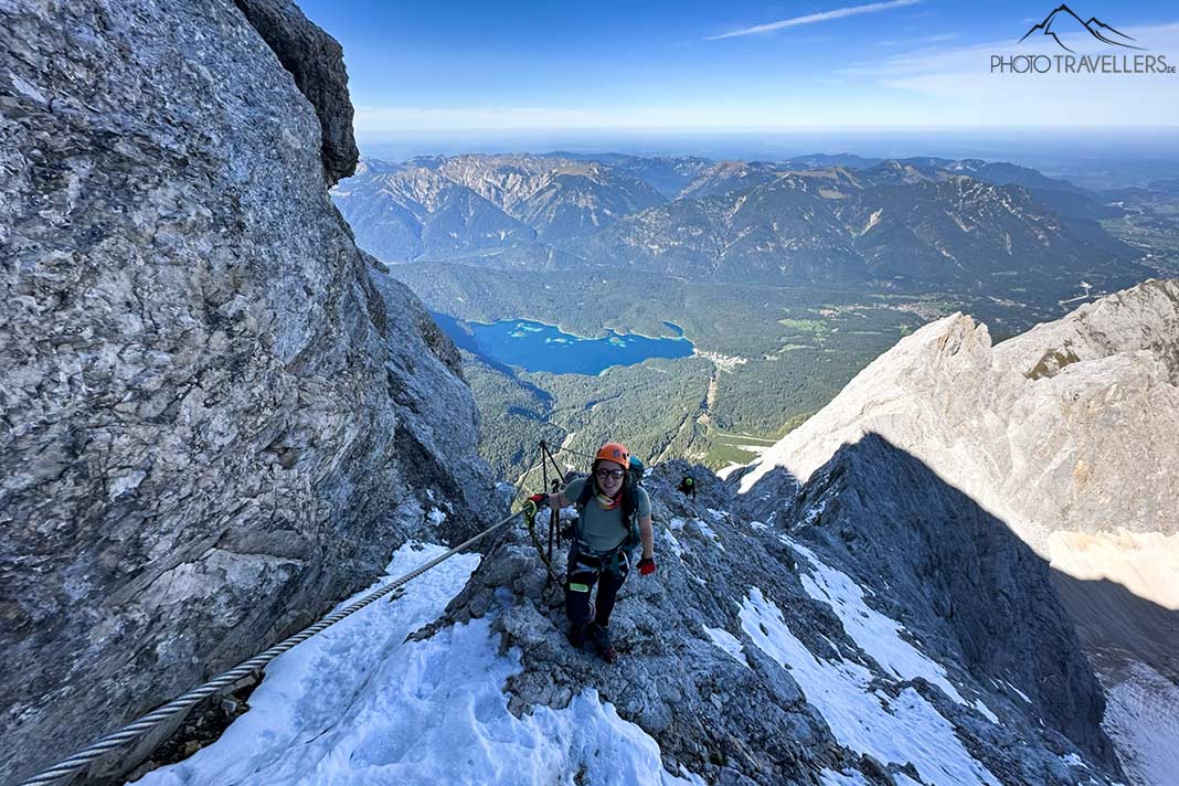 Reisebloggerin Biggi Bauer auf dem schneebedeckten Höllentalklettersteig mit Blick auf den Eibsee