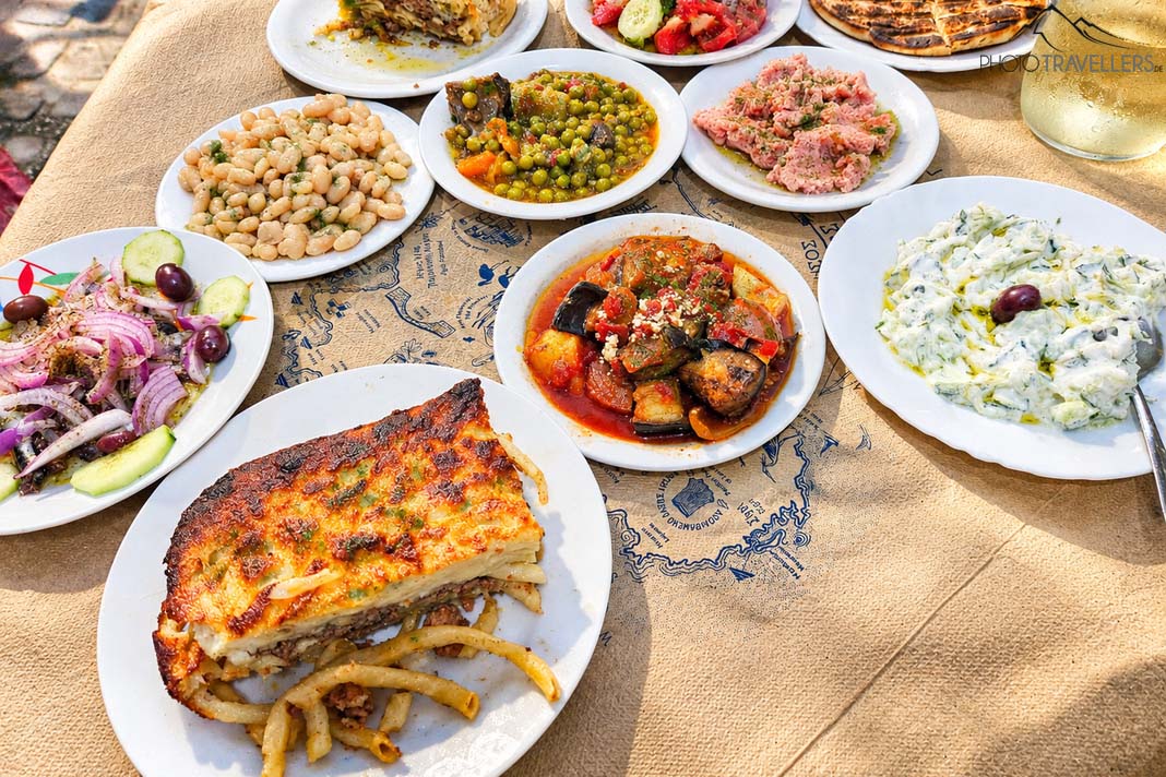 Viele kleine Teller mit griechischen Vorspeisen auf einem Tisch