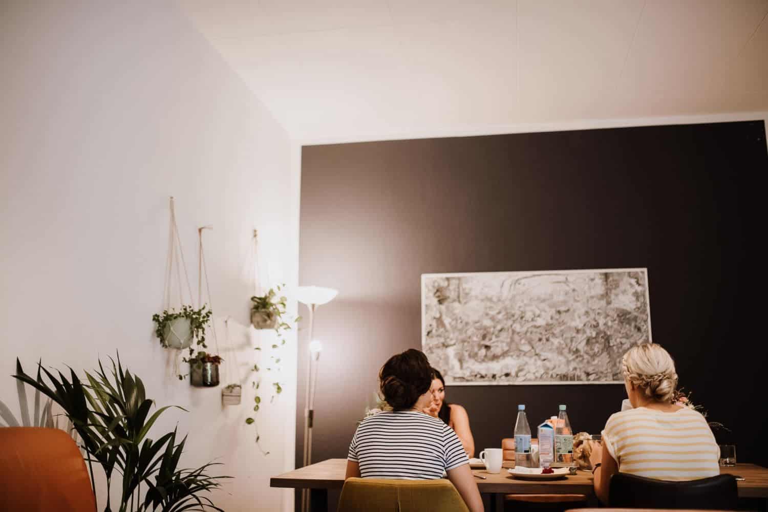 Drei Freunde genießen gemeinsam das Essen – echte Momente, Hochzeitsreportage NRW.