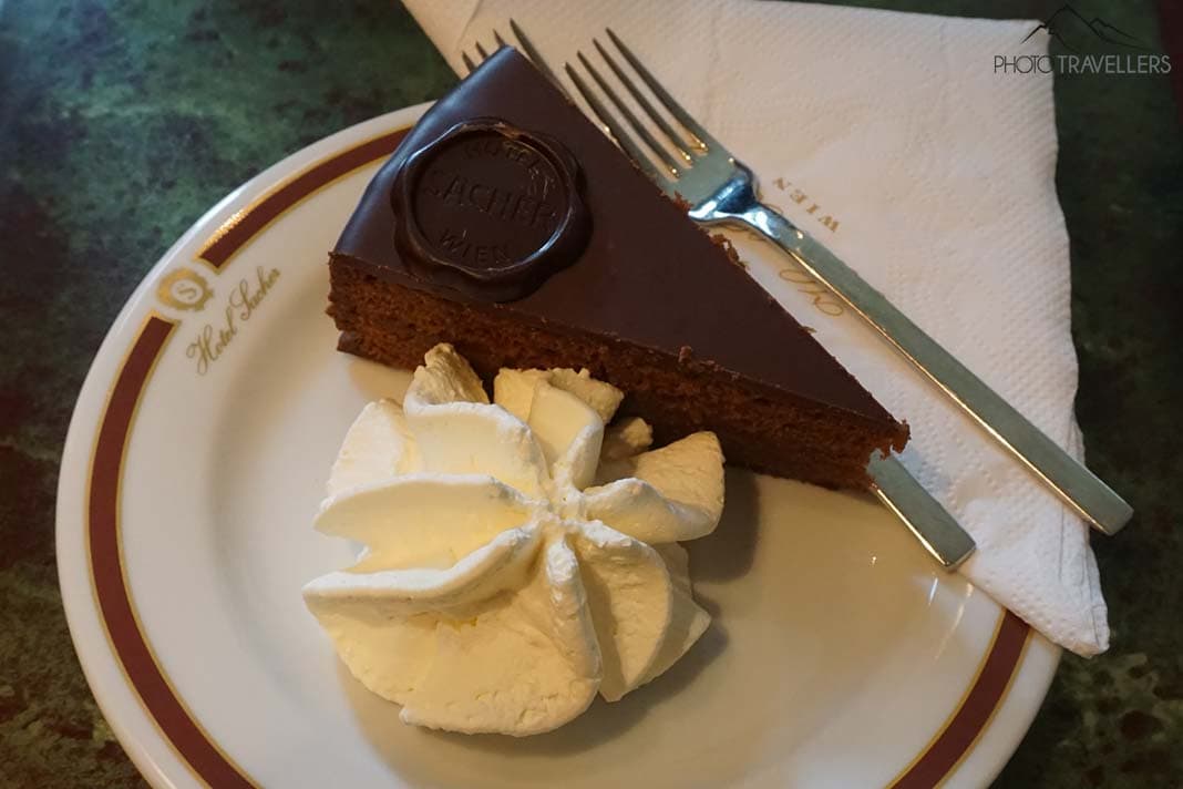 Eine Sacher-Torte mit Sahne auf einem Teller im Hotel Sacher in Wien