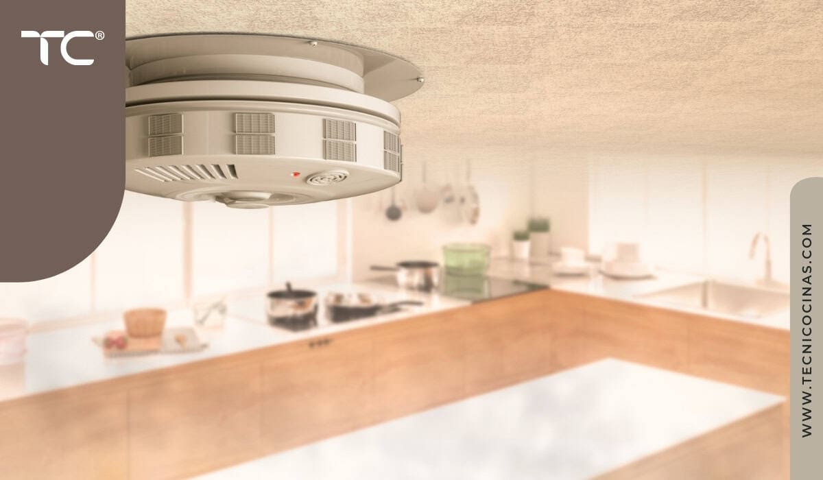 Detector de humo inteligente instalado en el techo de una cocina con humo ambiental