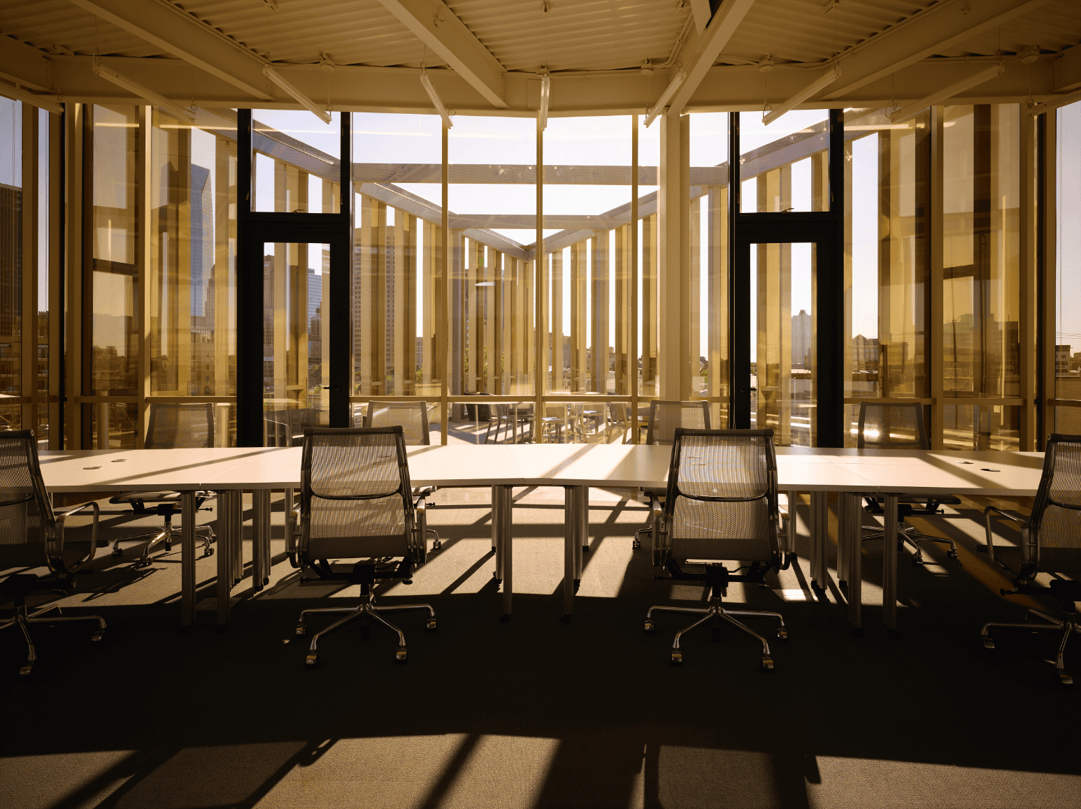 PLICO at the Flatiron conference room with golden glass walls and city views