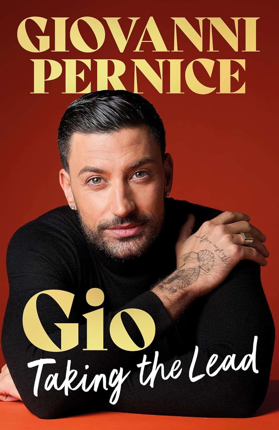 Book cover featuring Gio Pernice against an orange background with bold gold text 'GIOVANNI PERNICE' at the top and 'Gio Taking the Lead' in script at the bottom; close-up portrait of a man with dark hair and a tattooed hand.