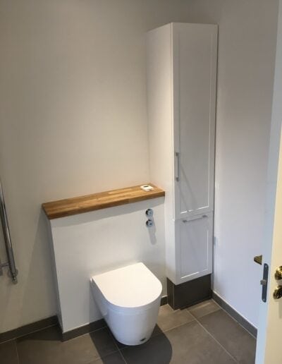 Elegant toilet med væghængt design og opbevaringsskab i badeværelse.
