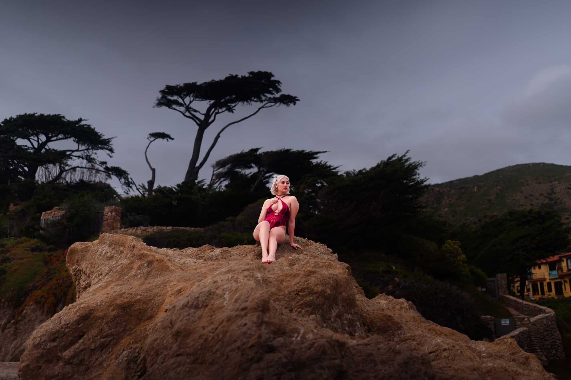 Beach Boudoir photography pose idea on a rock mound.