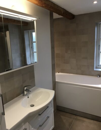 Badeværelse med badekar, vask og spejl i moderne hjem.