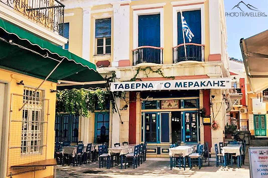 Leere Tischgarnituren stehen vor dem Gebäude der Taverne O Meraklis in Symi