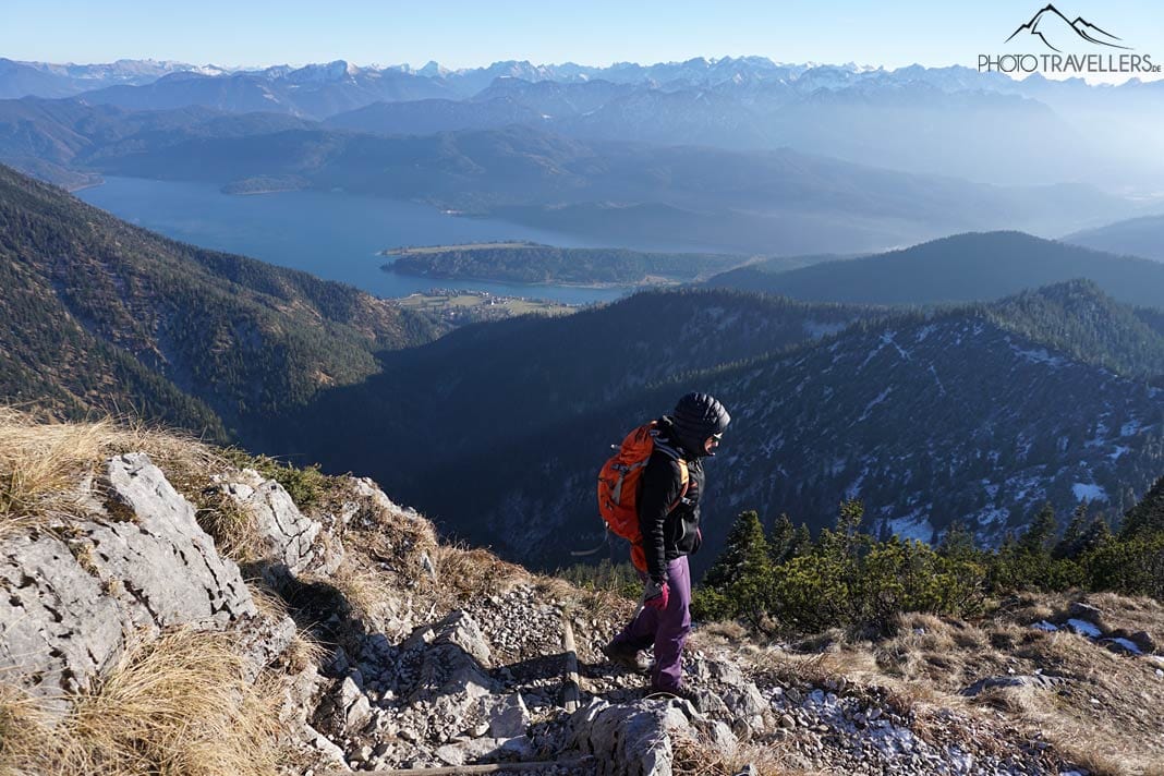 Reisebloggerin Biggi Bauer steigt einen felsigen Weg ab, im Hintergrund der Walchensee
