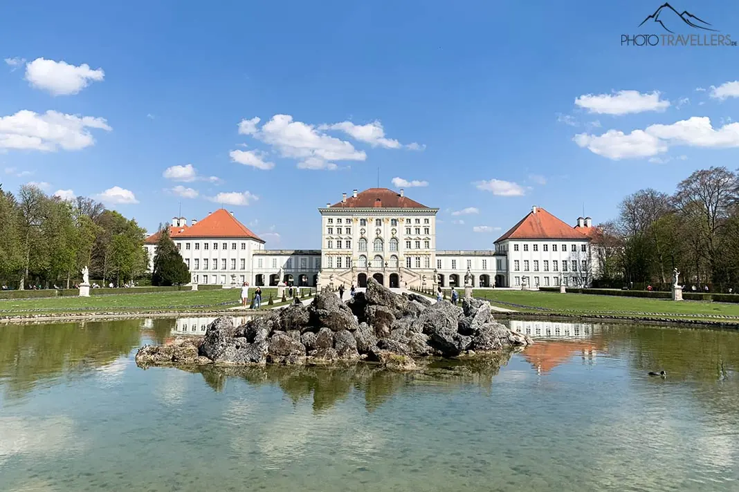 Ein Brunnen mit Schloss Nymphenburg im Hintergrund