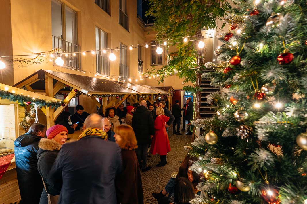 Besucher auf dem kleinen Weihnachtsmarkt der Weinbar Weinlobbyist in Berlin