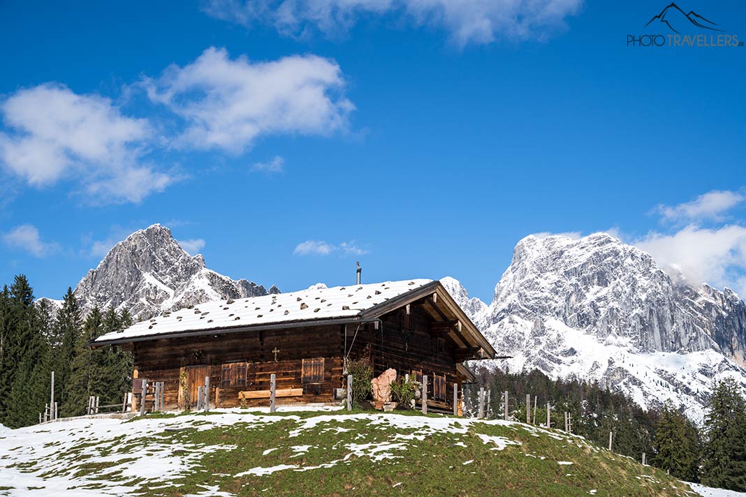 Eine Hütte auf der Litzalm mit Bergen im Hintergrund