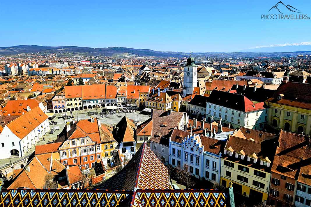 Blick von oben auf die Dächer von Sibiu mit dem weißen Ratsturm und dem Kleinen Ring im Hintergrund