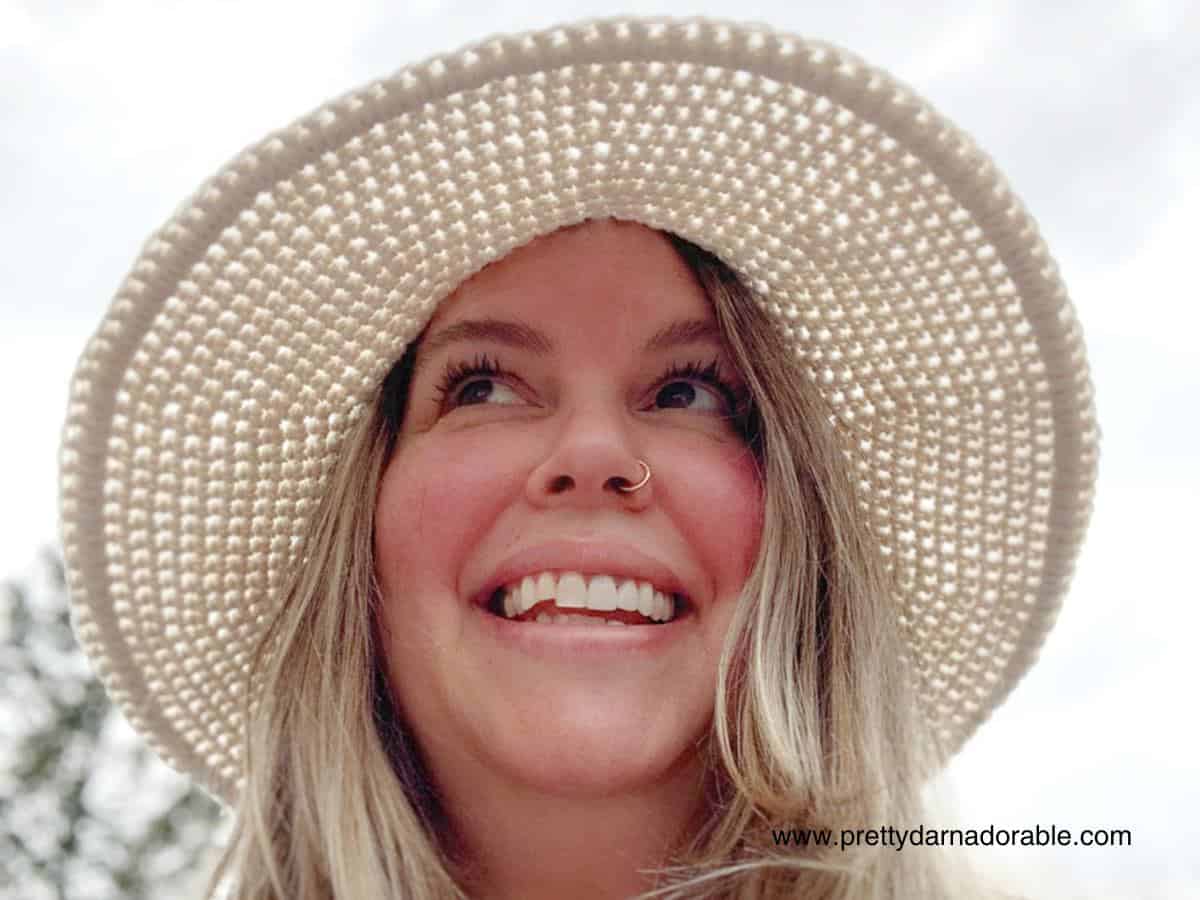 lady wearing cream crochet sun hat with a wide brim and lacey texture