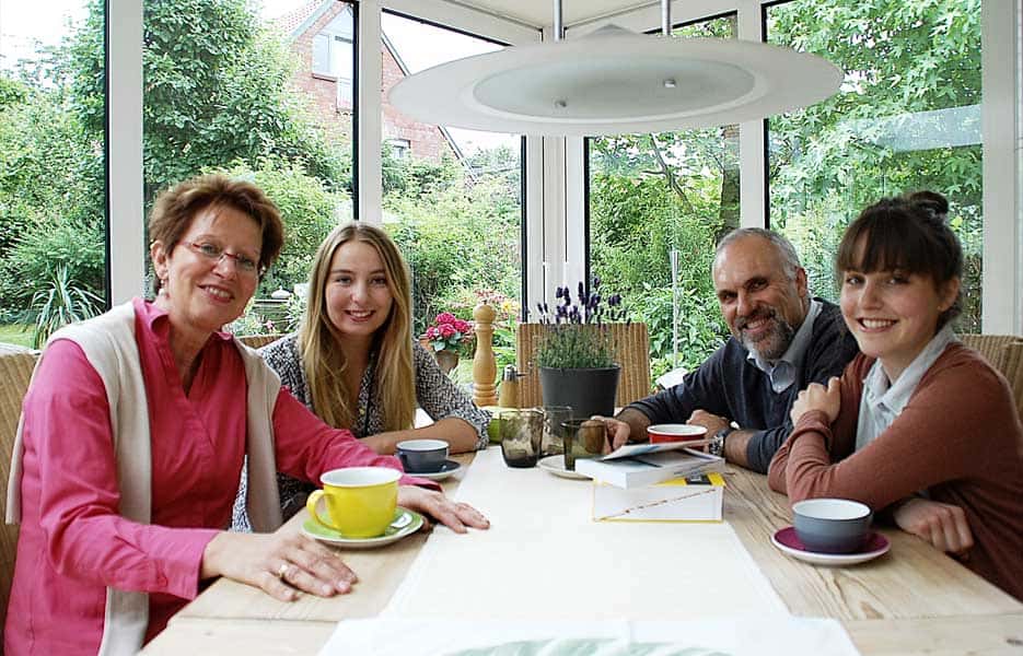 Unterkunft 3 Familie sitzt am Tisch im Wintergarten