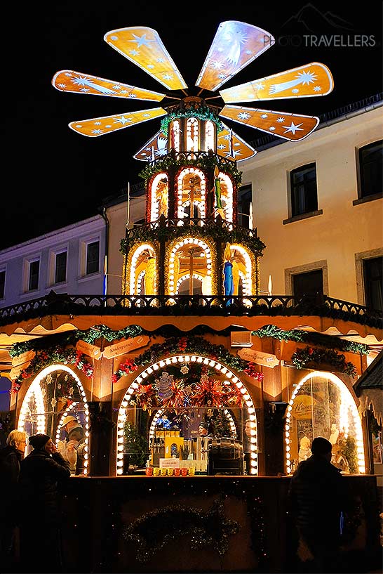 Ein als Windmühle dekorierter Stand auf dem Hofer Weihnachtsmarkt mit Besuchern im Vordergrund