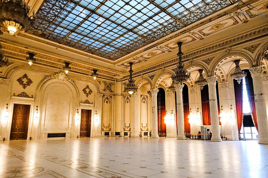 Prächtiger Saal im Parlamentspalast mit Marmorböden und Säulen, darüber ein Glasdach