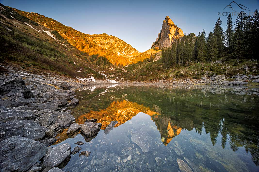 Der Riederecksee mit den angestrahlten Bergen, die sich im Wasser spiegeln