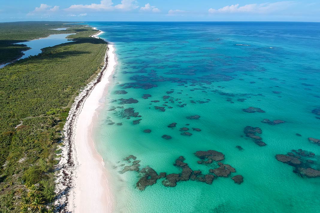 Der Strand des Greenwood Beach Resorts mit dem türkisgrünen Meer auf Cat Island auf den Bahamas von oben