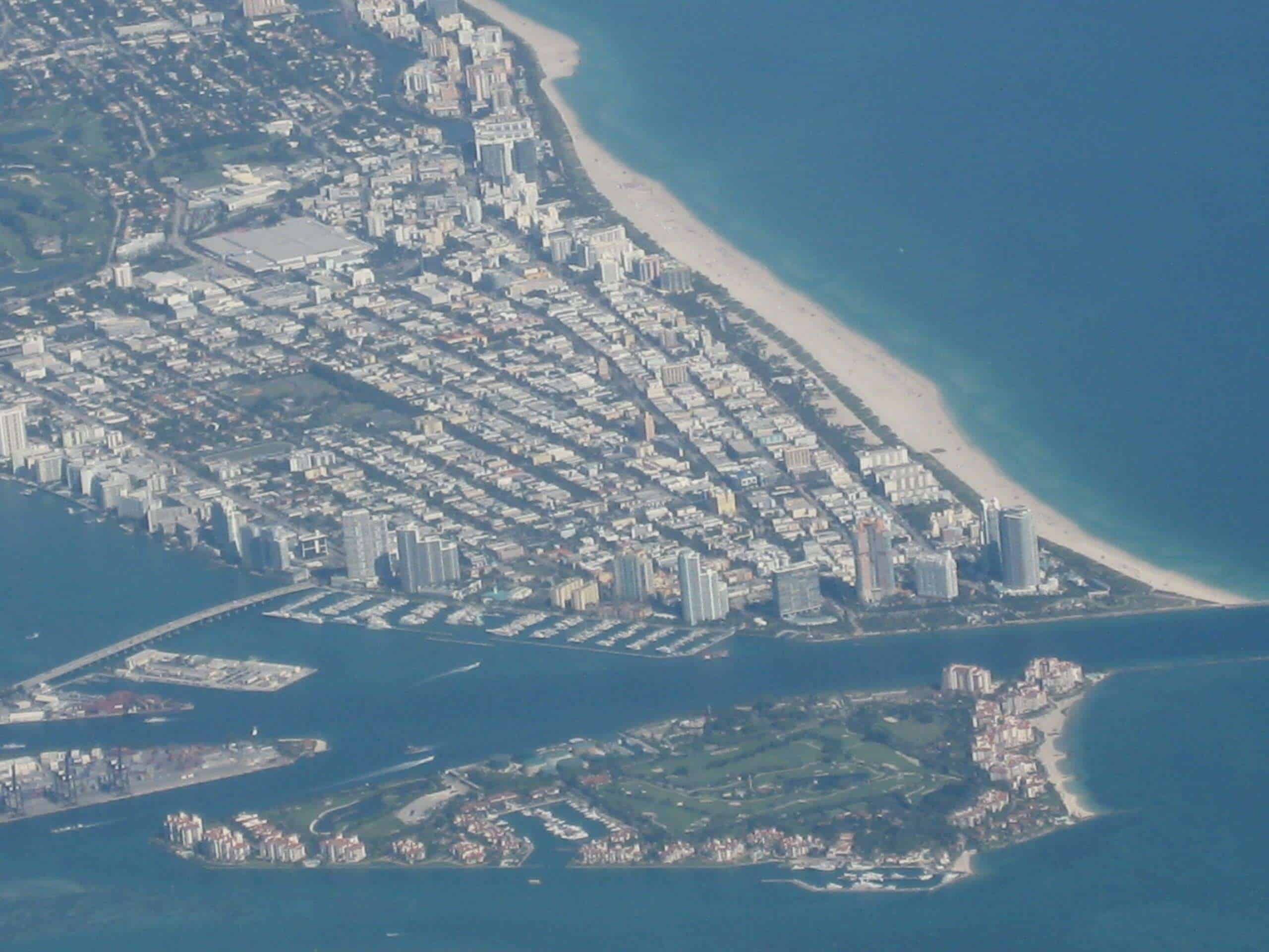 Himmelaufnahme von Miami, Florida mit Strand, Hochhäusern und Wasserwegen, zeigt die urbane Küstenlandschaft der USA.