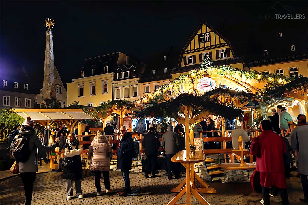 Viele Menschen stehen an den beleuchteten Ständen vor den Fachwerkhäusern am Kulmbacher Marktplatz