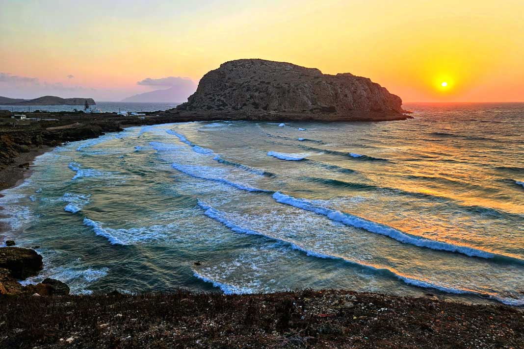 Der Blick auf den Felsen Paleiokastro, der die Bucht von Arkassa auf Karpathos in zwei Strände teilt