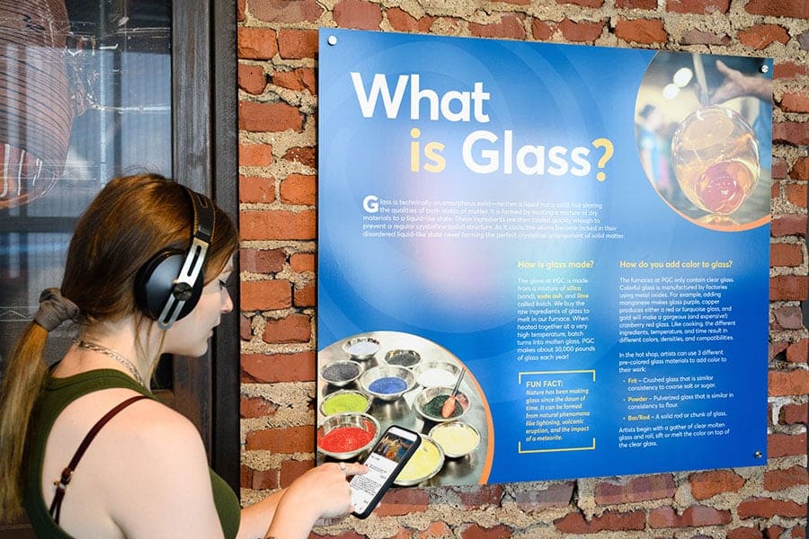 Visitor using headphones to listen to audio content in PGC's digital guide