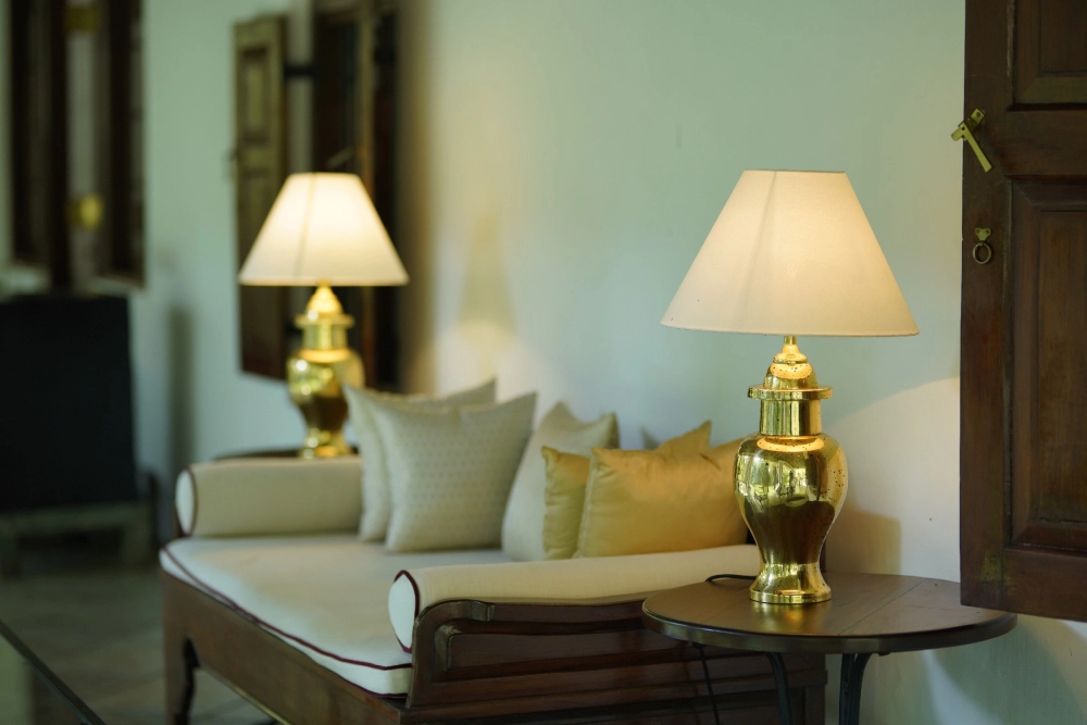 A white couch with decorative pillows in the Red Spot Duke room of Adigar's Manor.