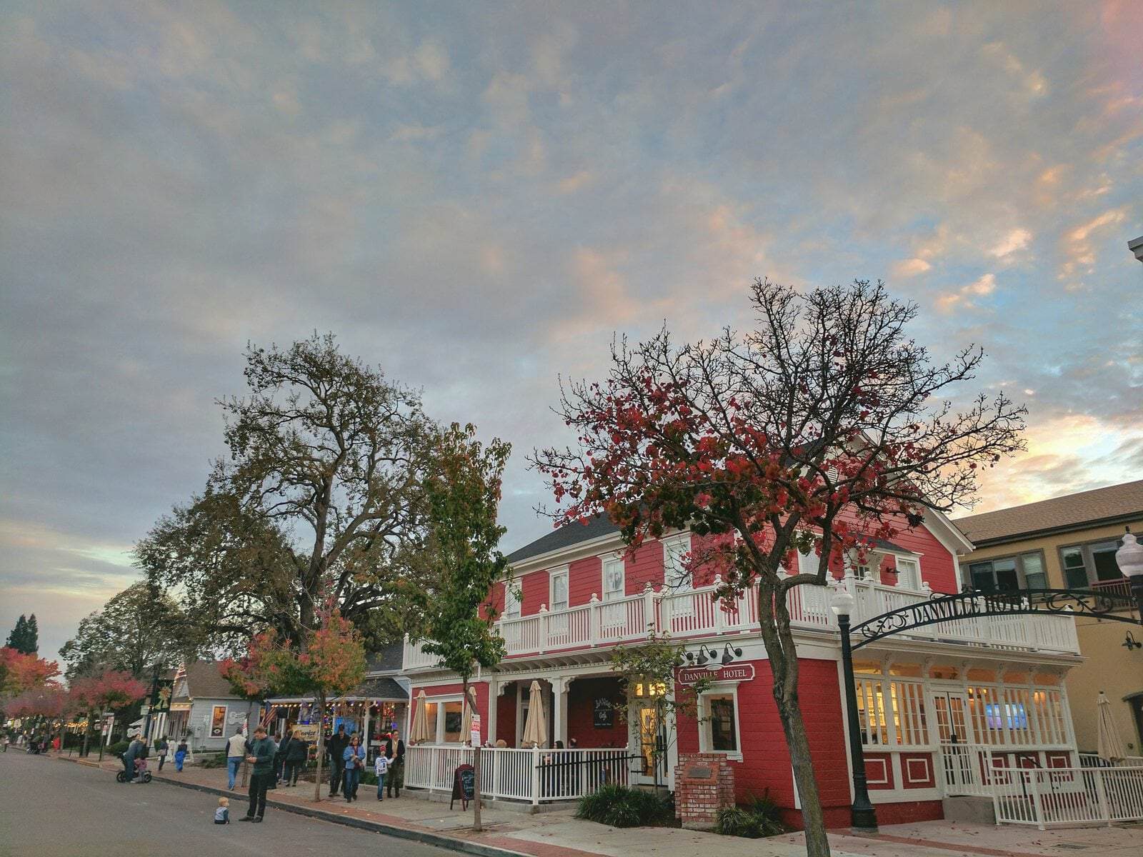 Hartz Avenue in downtown Danville, California, with a historic two-story red building, street trees in fall color and parked cars.