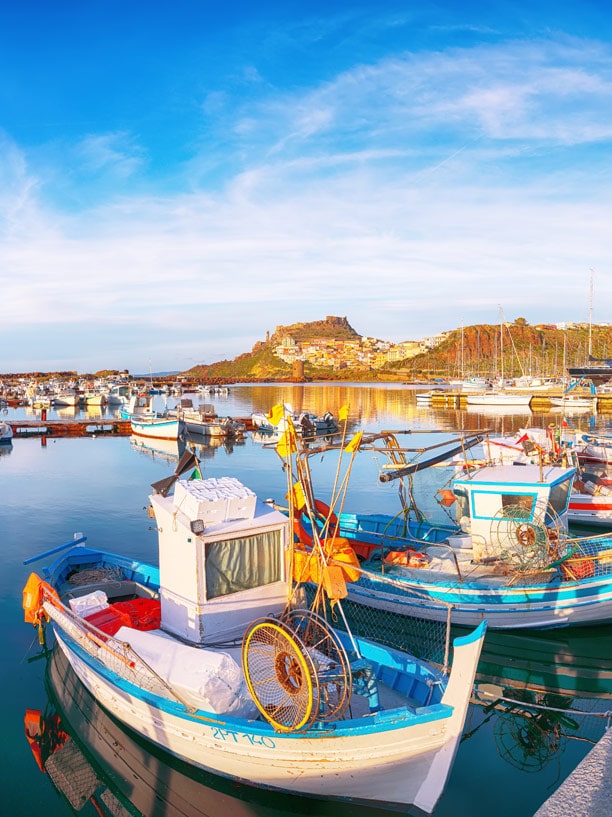 Boote mit der Stadt Castelsardo im Hintergrund