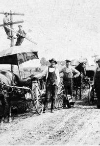 LeMert Telephone Vintage farming team with horse-drawn wagons and early 20th-century equipment in rural field.