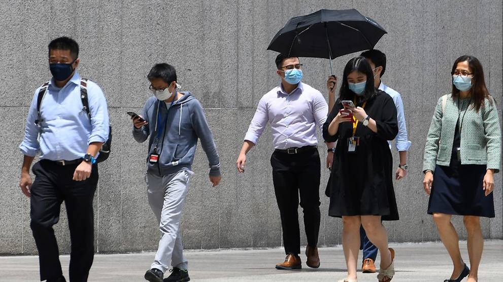 People walk out of their office building as they head for their lunch break in Singapore on Sep 30, 2020. (File photo: AFP/Roslan Rahman)