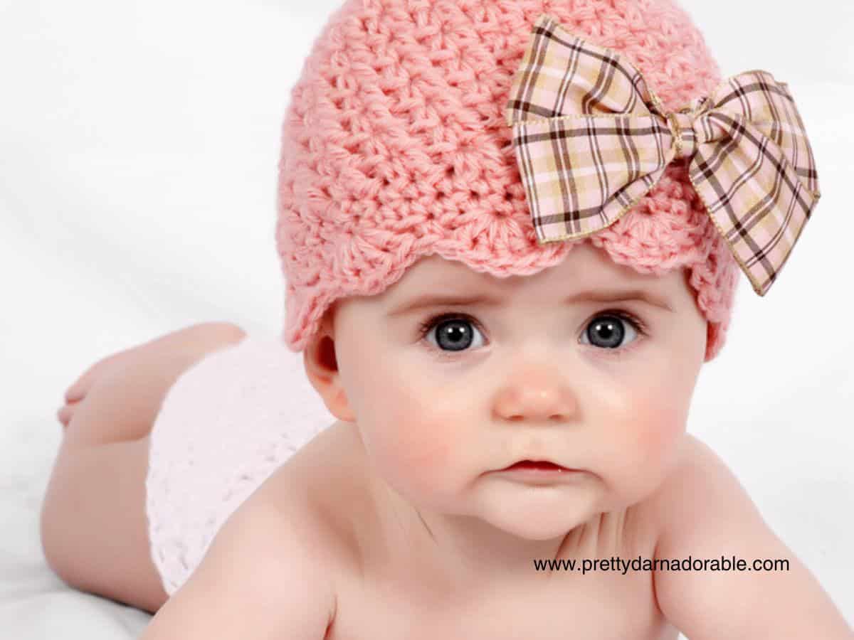 baby girl wearing pink crochet hat with bow - free crochet beanie hat pattern