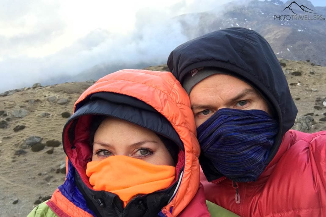 Die beiden Reisejournalisten Biggi Bauer und Florian Westermann verhüllen ihr Gesicht mit einem Multifunktionstuch als Schutz gegen Staub und Kälte in Nepal