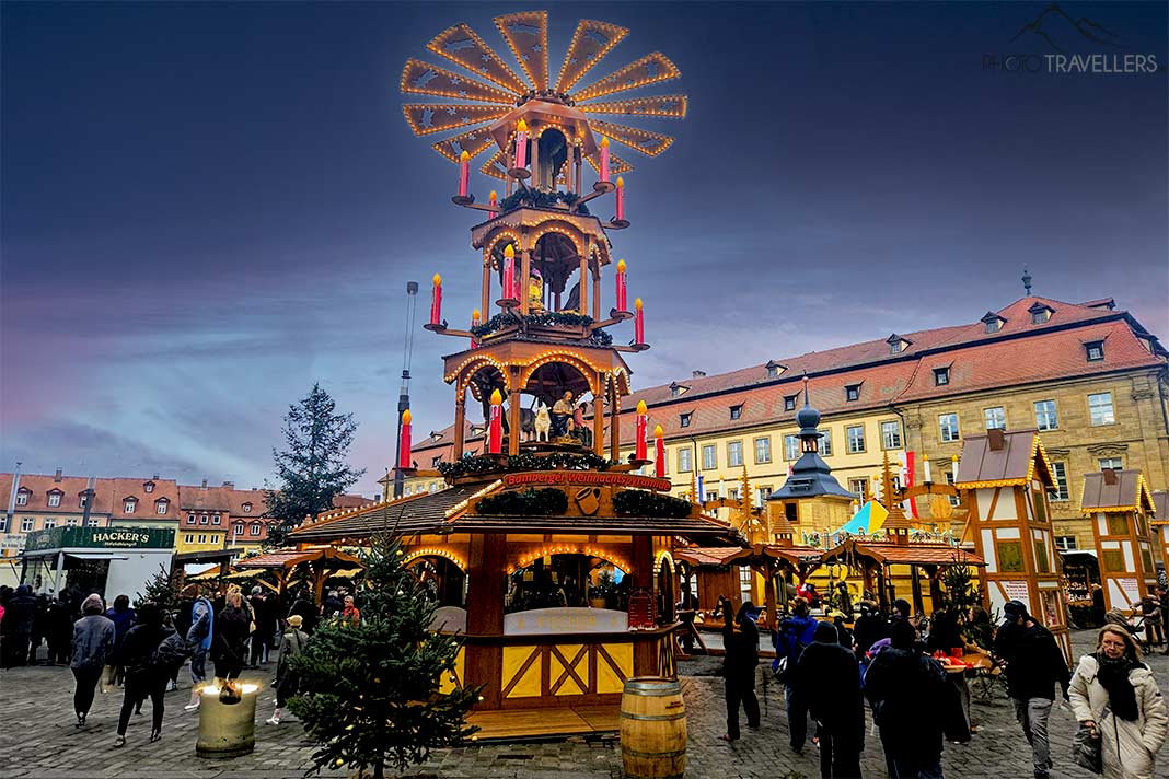 An den Ständen rund um die mehrstöckige Weihnachtsmühle auf dem Bamberger Weihnachtsmarkt stehen viele Menschen