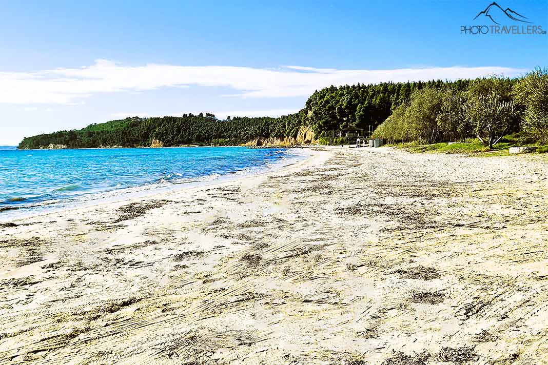 Weißer Sand und türkisblaues Wasser vor den bewachsenen Sandsteinfelsen am Simantro Beach