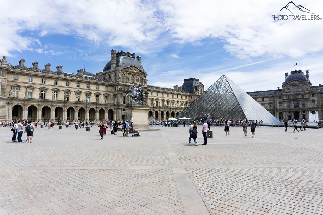Menschen vor der Glaspyramide des Louvre