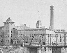 sbwoolen_thumb Old industrial factory with smokestacks and historic buildings.