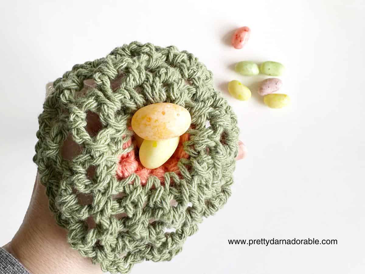 top of a crochet carrot with candy eggs inside